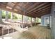 Charming covered porch featuring a wooden swing, string lights, and a serene wooded view, perfect for outdoor enjoyment at 671 Benson Hurst Sw Dr, Mableton, GA 30126