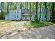 Two-story home featuring light blue siding and a welcoming front porch surrounded by lush trees at 671 Benson Hurst Sw Dr, Mableton, GA 30126