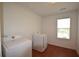 The well-lit laundry room boasts modern machines, a window, and red tile floors, making chores efficient and stylish at 671 Benson Hurst Sw Dr, Mableton, GA 30126