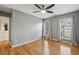 A spacious bedroom with hardwood floors, ceiling fan, and natural light from two windows with white curtains at 1016 Parkmont Way, Decatur, GA 30033