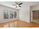 Bedroom with ceiling fan, hardwood floors, 3 windows, and a doorway leading to a tiled hallway at 1016 Parkmont Way, Decatur, GA 30033