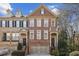 Beautiful three-story brick townhome featuring an attached two-car garage and manicured landscaping at 1016 Parkmont Way, Decatur, GA 30033