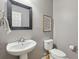 A compact powder room with a pedestal sink, a modern mirror, and a standard toilet at 1016 Parkmont Way, Decatur, GA 30033