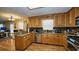 Well-lit kitchen featuring stainless steel appliances, wood cabinets, granite counters and hardwood floors at 1049 Fieldstone Dr, Canton, GA 30114