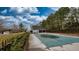 Community pool covered for the off-season, next to the tree line, featuring a fence and small pool house at 1049 Fieldstone Dr, Canton, GA 30114