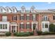 Charming brick townhome featuring dormer windows, black shutters, and manicured landscaping at 2620 Milford Ln, Alpharetta, GA 30009