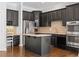 Well-equipped kitchen featuring dark cabinets, a center island, and modern appliances at 2620 Milford Ln, Alpharetta, GA 30009