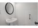 Bathroom with pedestal sink, round mirror, and accessible grab bar at 2620 Milford Ln, Alpharetta, GA 30009