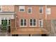 Back exterior of a brick home with a wooden deck and garage access at 2620 Milford Ln, Alpharetta, GA 30009