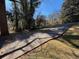 View of a driveway leading to a home covered by tree shadows and surrounded by a grassy lawn at 5169 Oxbow Rd, Stone Mountain, GA 30087