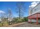 Well-maintained backyard featuring mature trees, green shrubs and an elevated deck with red railings at 826 Shore Dr, Lithonia, GA 30058