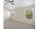 Bright bedroom with a ceiling fan and two windows with views of the green foliage at 826 Shore Dr, Lithonia, GA 30058