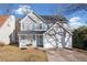 Charming two-story home with a two car garage, mature trees, and a well maintained front lawn at 826 Shore Dr, Lithonia, GA 30058