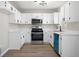 Modern kitchen with white cabinetry, stainless steel appliances, and a contrasting blue dishwasher at 826 Shore Dr, Lithonia, GA 30058