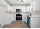 Well-lit kitchen features white cabinets, stainless steel appliances, and wood-look flooring at 826 Shore Dr, Lithonia, GA 30058