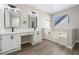 Bright main bathroom with dual sinks, granite counters, new faucets and a soaking tub at 826 Shore Dr, Lithonia, GA 30058