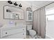 Bright bathroom featuring a sleek white vanity, a black framed mirror, and a shower with a stylish curtain at 1015 Michigan Nw Ave, Atlanta, GA 30314