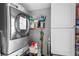 Functional laundry room with stacked washer and dryer, storage shelves, and white cabinets at 1015 Michigan Nw Ave, Atlanta, GA 30314