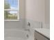 Bathroom featuring a soaking tub with marble backsplash underneath a large window at 1079 Blue Juniper Cir, Loganville, GA 30052