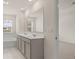 Elegant bathroom with double vanity, large mirror, tile floor, and soaking tub under a window at 1079 Blue Juniper Cir, Loganville, GA 30052