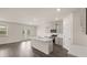 Modern kitchen with white island, stainless steel appliances, wood flooring, and open layout at 1079 Blue Juniper Cir, Loganville, GA 30052