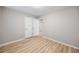 An empty bedroom featuring wood-look flooring, neutral colored walls, and closet doors at 1107 Sanfords Walk, Tucker, GA 30084