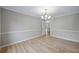 Dining room features decorative chandelier, chair rail, wood-look flooring, and neutral paint at 1107 Sanfords Walk, Tucker, GA 30084