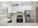 White kitchen with stainless appliances and granite countertops at 1107 Sanfords Walk, Tucker, GA 30084