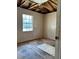 Bedroom with damaged walls, unfinished floors, a window, and exposed rafters overhead at 13101 Waldrop Cv, Decatur, GA 30034