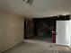 Living room with visible wall framing, unfinished floors and an adjacent doorway to the outside at 13101 Waldrop Cv, Decatur, GA 30034