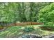 Well-maintained backyard featuring a lush lawn, mature trees, and a wooden fence at 5080 Firelight Ln, Alpharetta, GA 30022