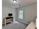 Neutral bedroom featuring gray walls and carpet, window, and desk with computer set up at 5080 Firelight Ln, Alpharetta, GA 30022