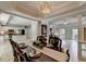 Bright dining room featuring elegant chandelier, decorative columns, and open flow to kitchen and living areas at 5080 Firelight Ln, Alpharetta, GA 30022