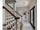 Inviting foyer featuring tiled floor, stairway with wood railings, decorative light fixture, and modern front door at 5080 Firelight Ln, Alpharetta, GA 30022