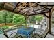 Charming covered gazebo with ceiling fan, table, and chairs overlooking backyard at 5080 Firelight Ln, Alpharetta, GA 30022