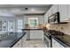 Kitchen features stainless steel appliances, black countertops, and natural light from the window at 5080 Firelight Ln, Alpharetta, GA 30022