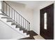 Bright entryway featuring hardwood floors, staircase with black iron railing, and a decorative front door at 5664 Colton Dr, Atlanta, GA 30342