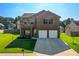 A two-story brick home is displayed in this exterior shot with a well-manicured lawn and a two-car garage at 6101 Providence Way, Union City, GA 30291