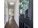 Long hallway with hardwood floors, white walls, decorative lights, and doors leading to the living areas at 6101 Providence Way, Union City, GA 30291