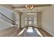 Sunlit open floorplan living room featuring new flooring, large windows, and view to foyer staircase at 8103 White Oak Loop, Stone Mountain, GA 30038