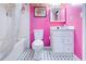 Vibrant bathroom with a pink wall, white fixtures, and patterned flooring at 175 Hampstead Mnr, Fayetteville, GA 30214