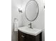 Elegant half-bathroom featuring a dark wood vanity with a white sink, a stylish faucet, and a decorative mirror at 611 Irwin Ne St, Atlanta, GA 30312
