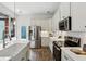 Well-lit modern kitchen featuring white cabinets, stainless steel appliances, and a view of the outdoor patio at 611 Irwin Ne St, Atlanta, GA 30312