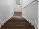 Interior staircase featuring hardwood steps, white walls, and modern design at 975 Moda Dr, Atlanta, GA 30316