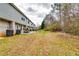 The exterior features a long backyard surrounded by trees and grass and a small patio at 1155 Magnolia Gardens Walk, Mcdonough, GA 30253