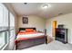 A cozy bedroom featuring a wooden bed frame, bright orange bedding, and natural light from a nearby window at 1155 Magnolia Gardens Walk, Mcdonough, GA 30253
