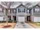 Inviting townhome exterior features gray siding, brick accents, an attached garage, and well-maintained landscaping at 1155 Magnolia Gardens Walk, Mcdonough, GA 30253