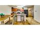 Open kitchen featuring an island with seating, wood cabinets, modern appliances, and tile floors at 1155 Magnolia Gardens Walk, Mcdonough, GA 30253