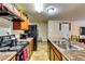 Kitchen featuring stone countertops, stainless appliances, a range hood, and an island with a sink at 1155 Magnolia Gardens Walk, Mcdonough, GA 30253