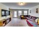 Bright living room featuring a comfortable sofa, large windows, a TV, and open access to other living spaces at 1155 Magnolia Gardens Walk, Mcdonough, GA 30253